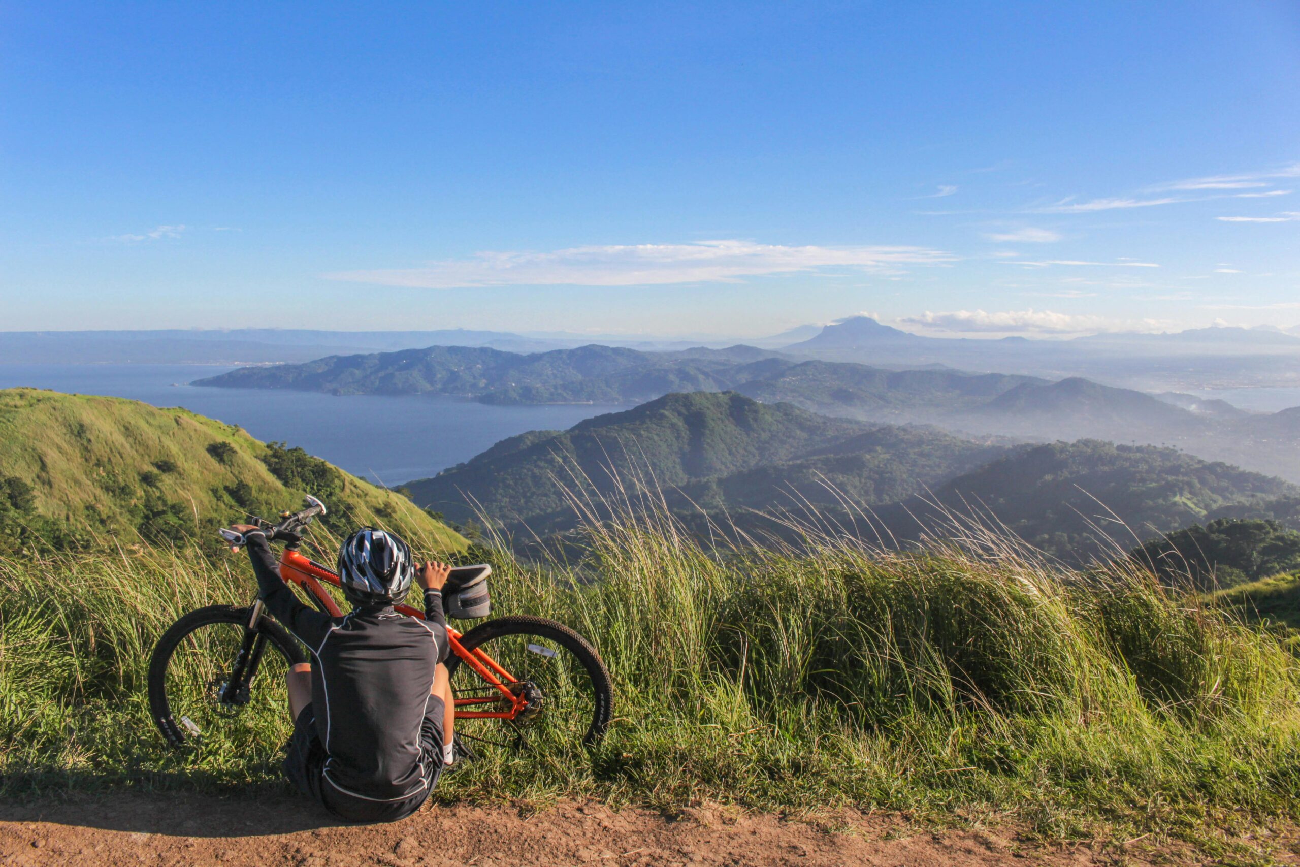 Ciclista che riposa e guarda le montagne